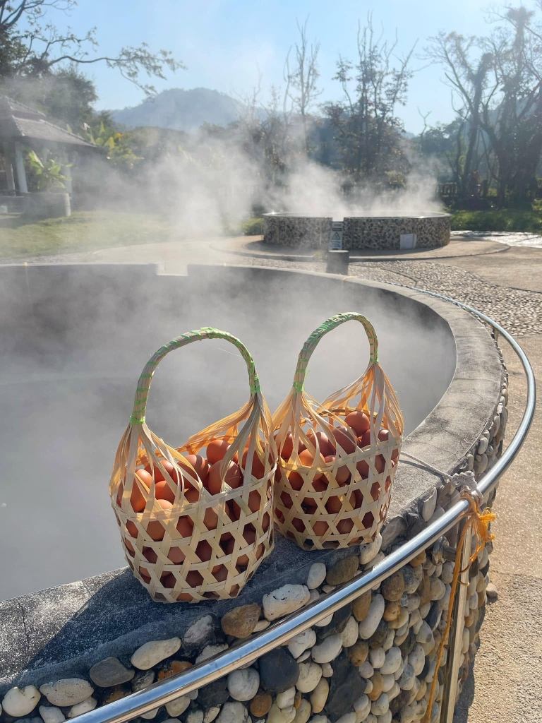 Steaming mineral hot spring pools with woven bamboo egg baskets