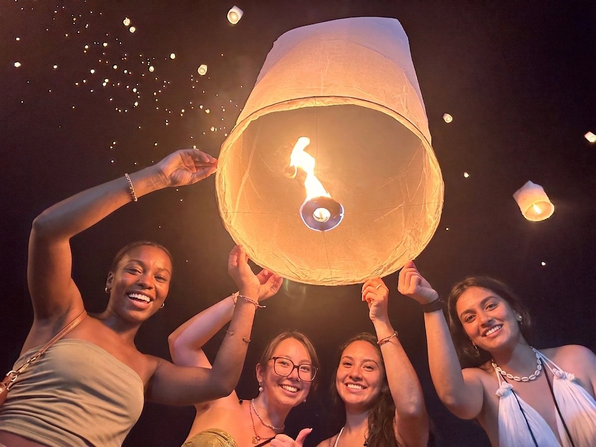 Friends releasing sky lantern together